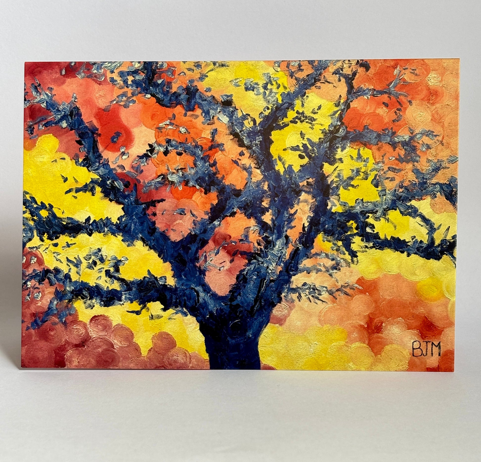 Colorful abstract painting of a tree with autumnal colors on a white background