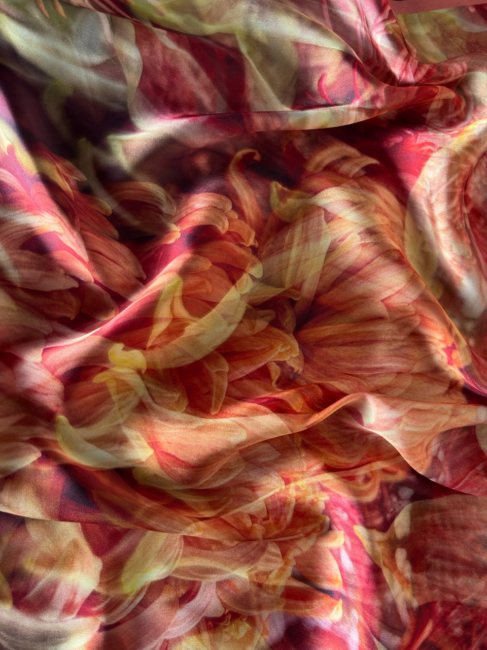 Abstract floral artwork with layered, swirling petals in warm red, pink, cream, and yellow tones.